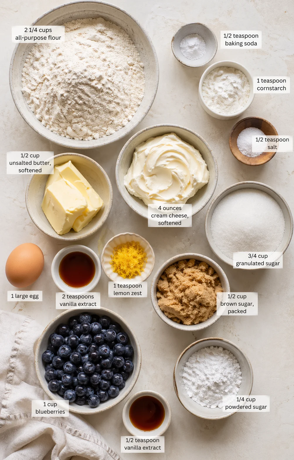 Top-down view of baking ingredients laid out with labeled amounts on a light marble surface