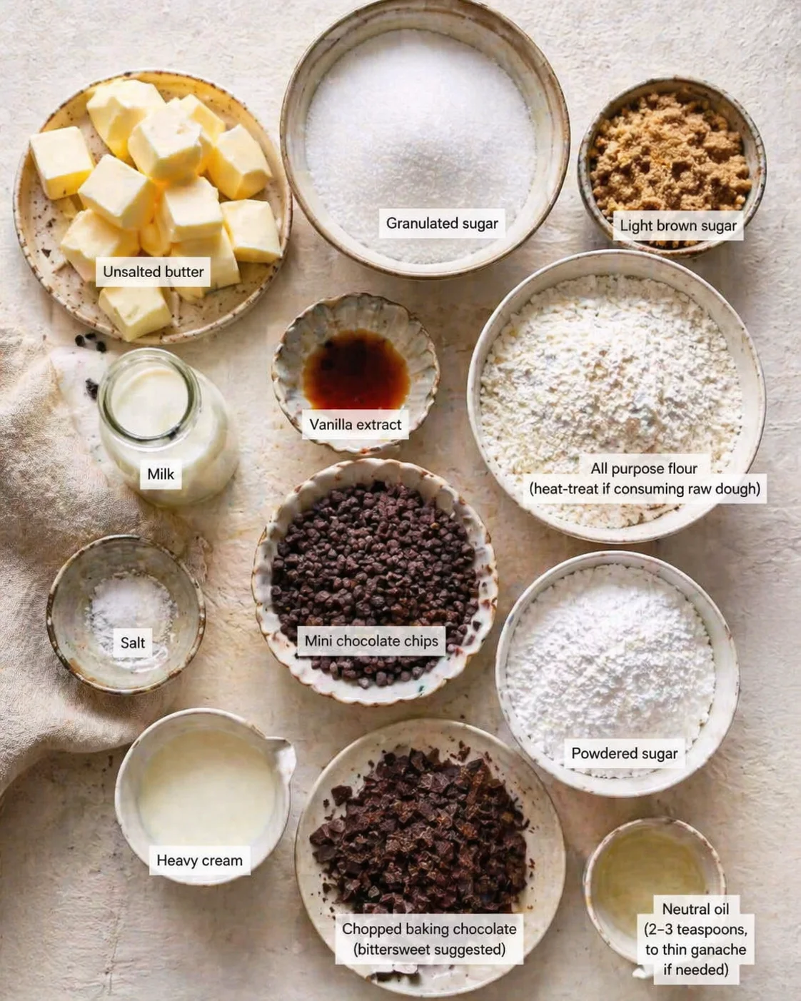 top-down flat lay of labeled baking ingredients for cookies on a light textured surface