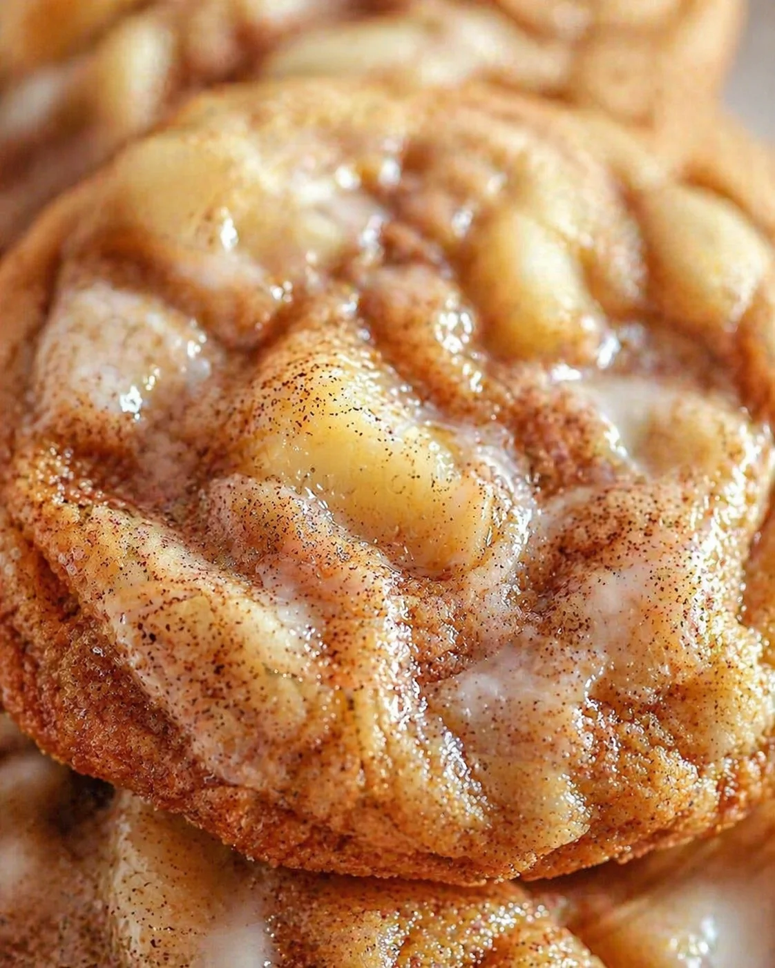 close-up of a glossy cinnamon roll with cinnamon-sugar coating and butter glaze