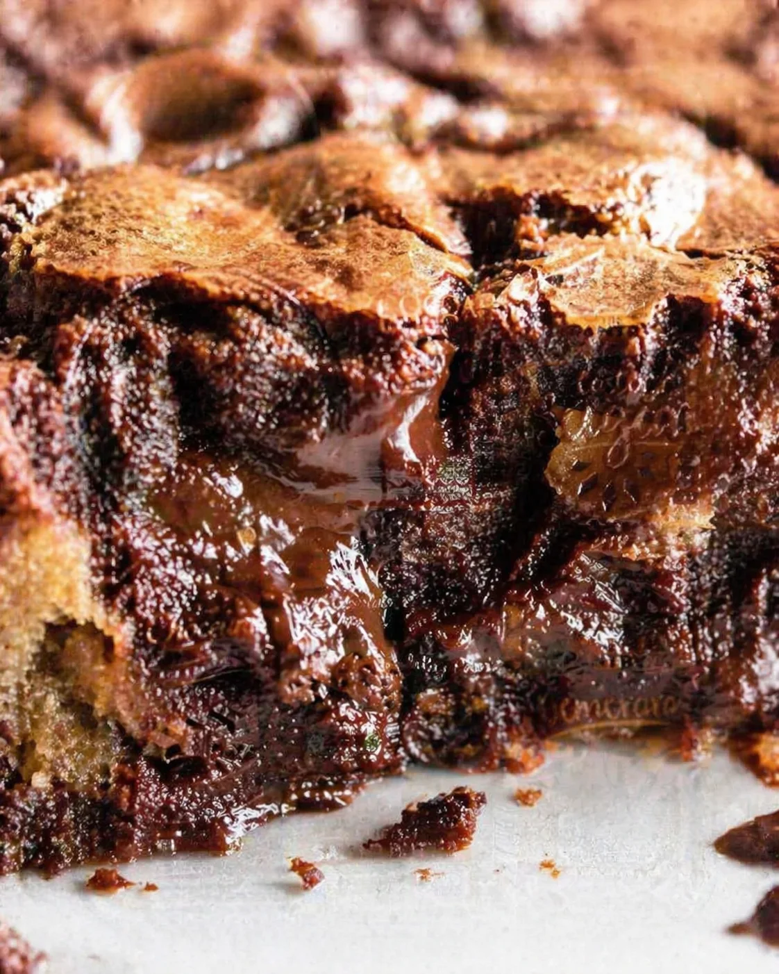 close-up of a gooey fudgy chocolate brownie with glossy crust