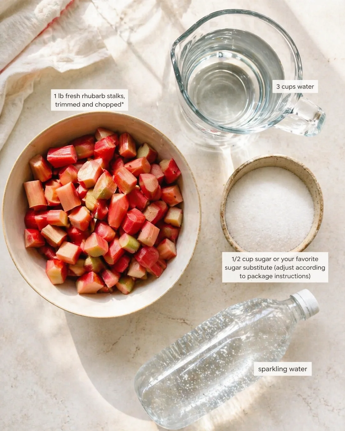 Top-down shot of chopped rhubarb in a bowl with water, sugar, and sparkling water on a light counter