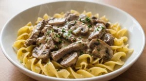 Delicious beef stroganoff served over noodles with creamy mushroom sauce