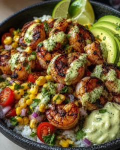Close-up of grilled shrimp served over rice with avocado and lime slices