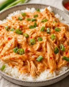 Delicious slow cooker sweet chili chicken over rice garnished with green onions