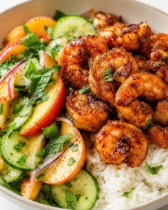 Plated bowl with seared shrimp, white rice, and cucumber-peach mint salad.