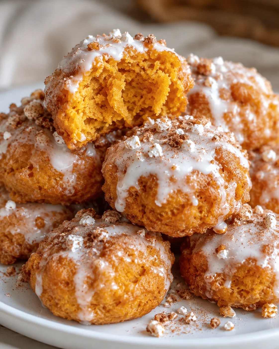 Delicious baked pumpkin fritter bites topped with glaze and powdered sugar