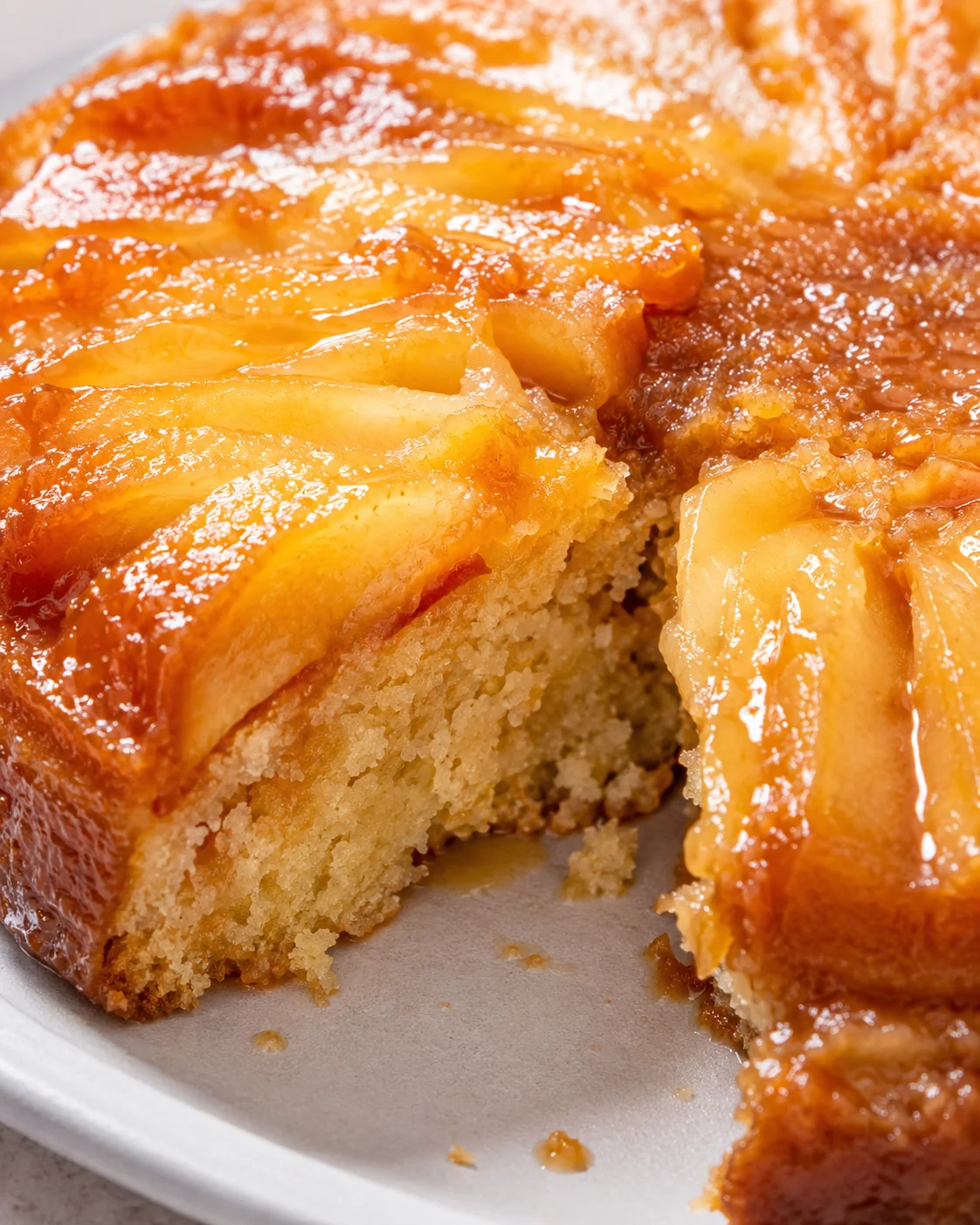 A close-up of finished apple upside down cake revealing caramelized apple slices on top.