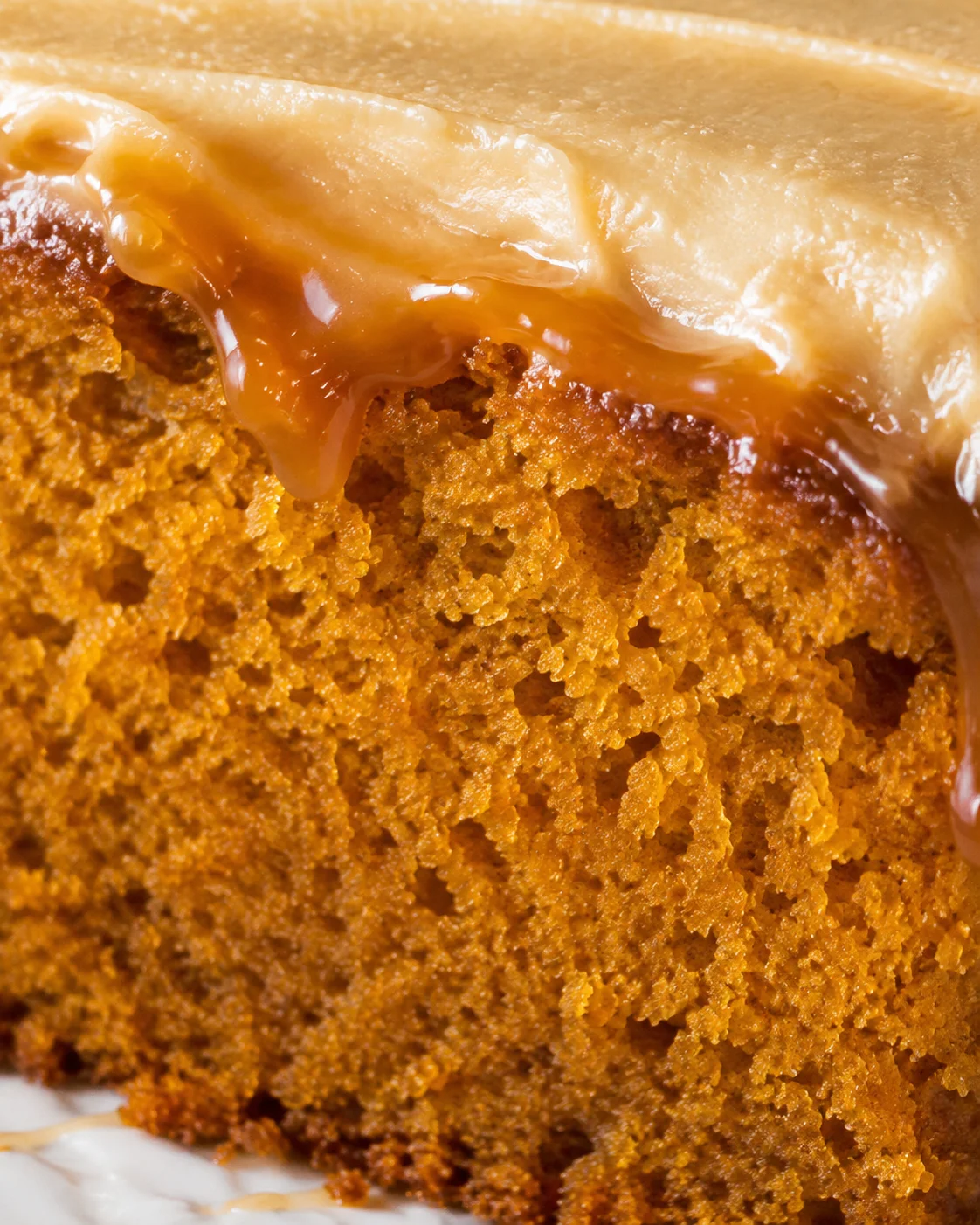Close-up of moist pumpkin cake topped with creamy caramel frosting