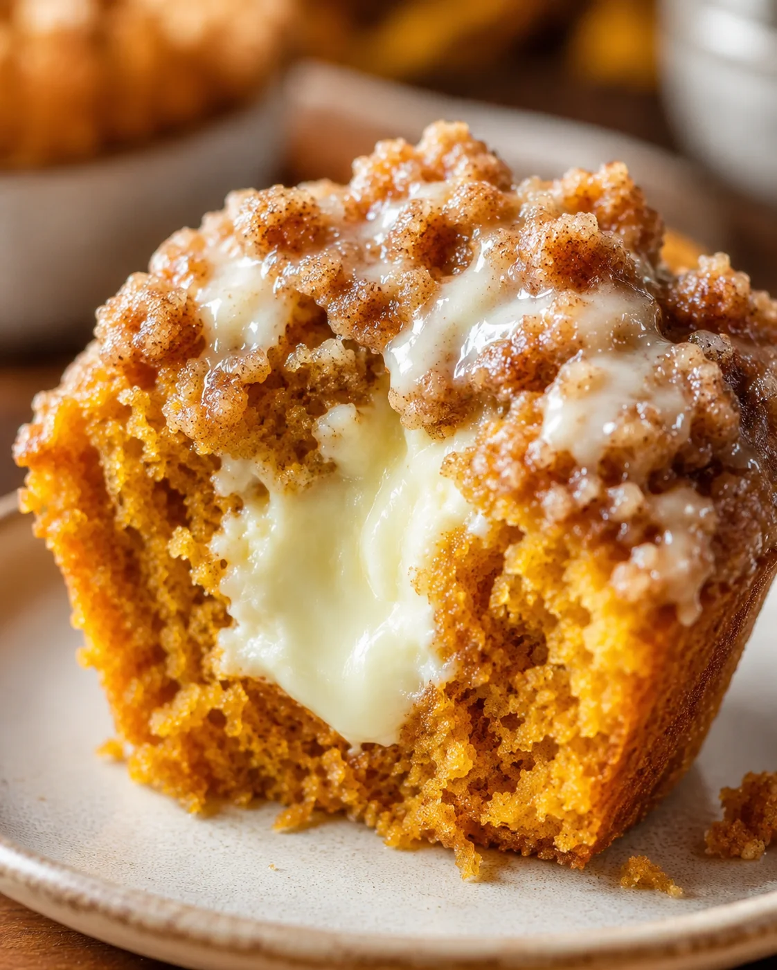 Close-up of a moist pumpkin muffin with creamy center and streusel topping