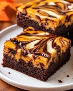 Close-up of marbled pumpkin and chocolate brownies on a plate.