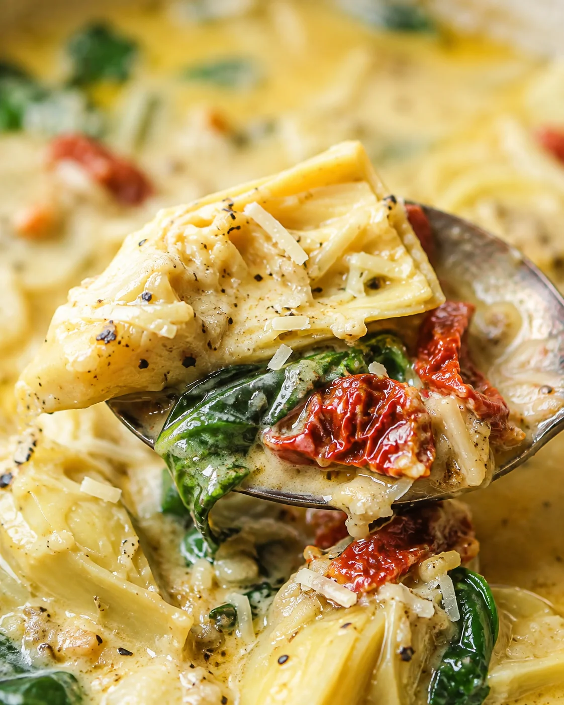 Spoonful detail of artichoke, spinach and sun-dried tomato in lemony Tuscan artichoke soup