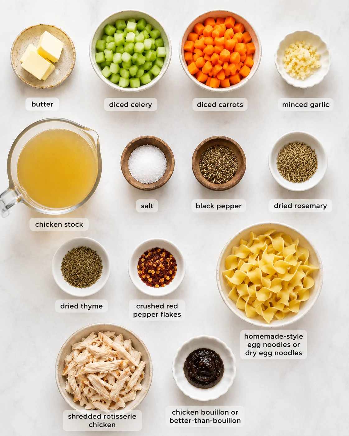 Top-down arrangement of measured ingredients for chicken noodle soup including butter, celery, carrots, garlic, stock, spices, noodles and shredded chicken