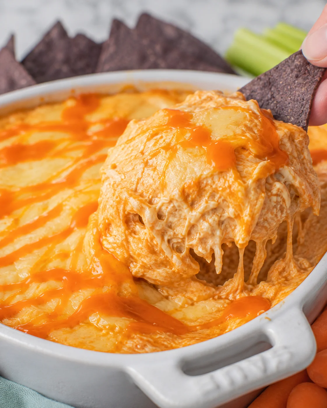 Creamy and spicy buffalo chicken dip with melted cheese in a baking dish.